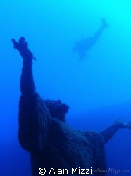 Diver swimming over statue of Jesus. by Alan Mizzi 